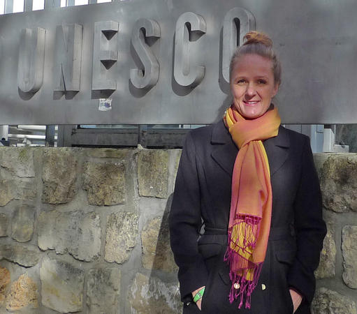 Portrait of Inger Måren standing besides the UNESCO nameplate