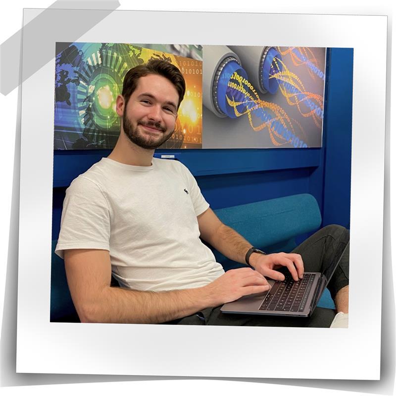 Mann ser inn i kamera med en laptop på fanget