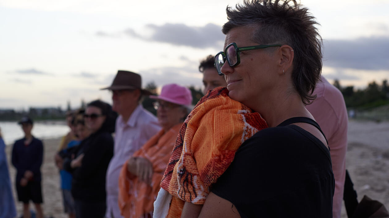 Seen from the side, a woman with short hair and glasses, in a black top