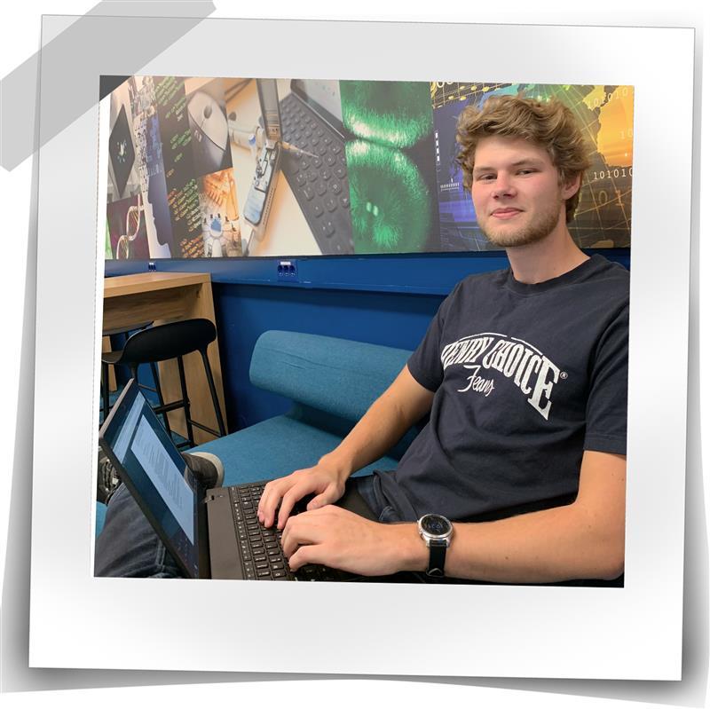 Mann ser inn i kamera med en laptop på fanget