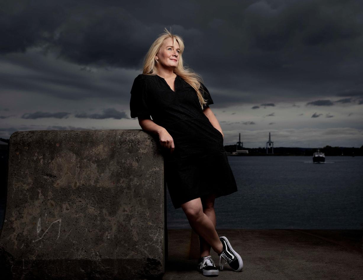 Bilde av Marit Eikemo foran landskap.