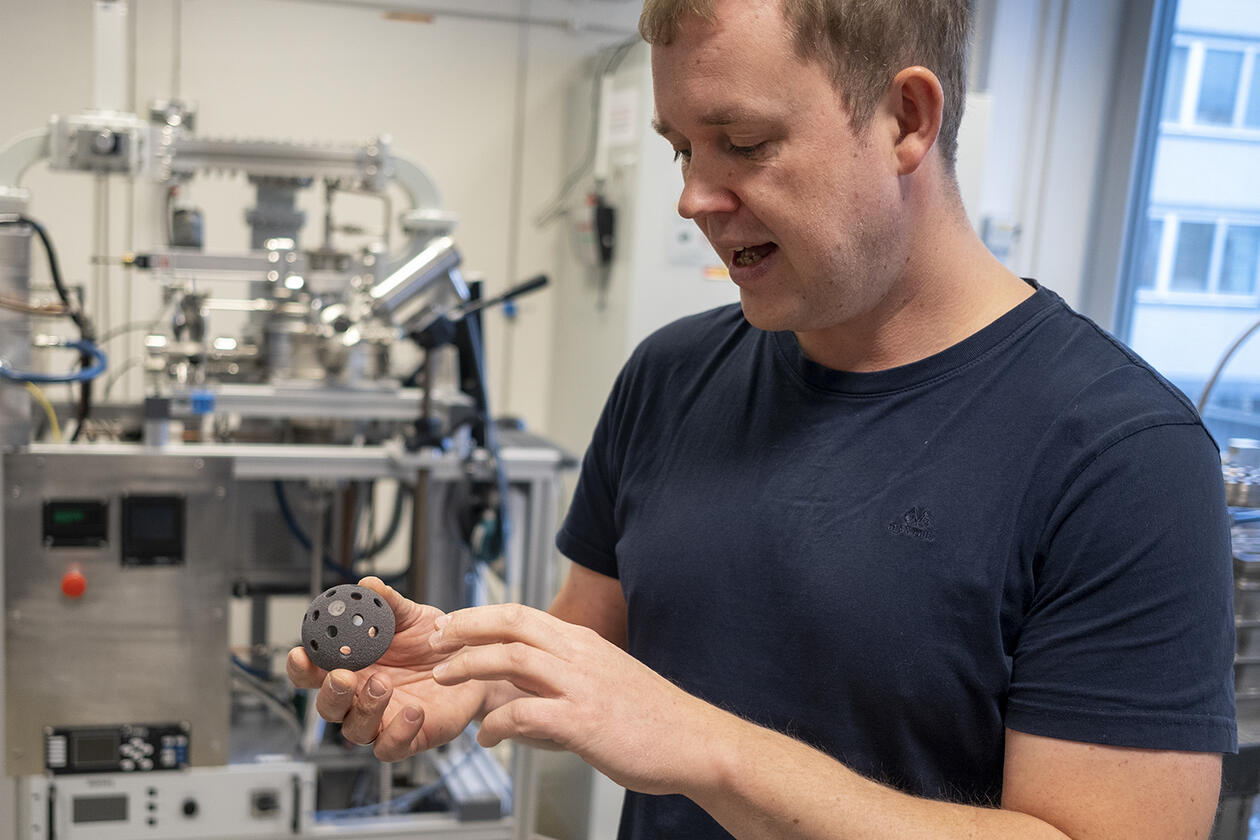 Forsker Justas Zalieckas viser frem en del av en hofteprotese som han ønsker å legge diamantbelgg på for å sikre best mulig integrasjon