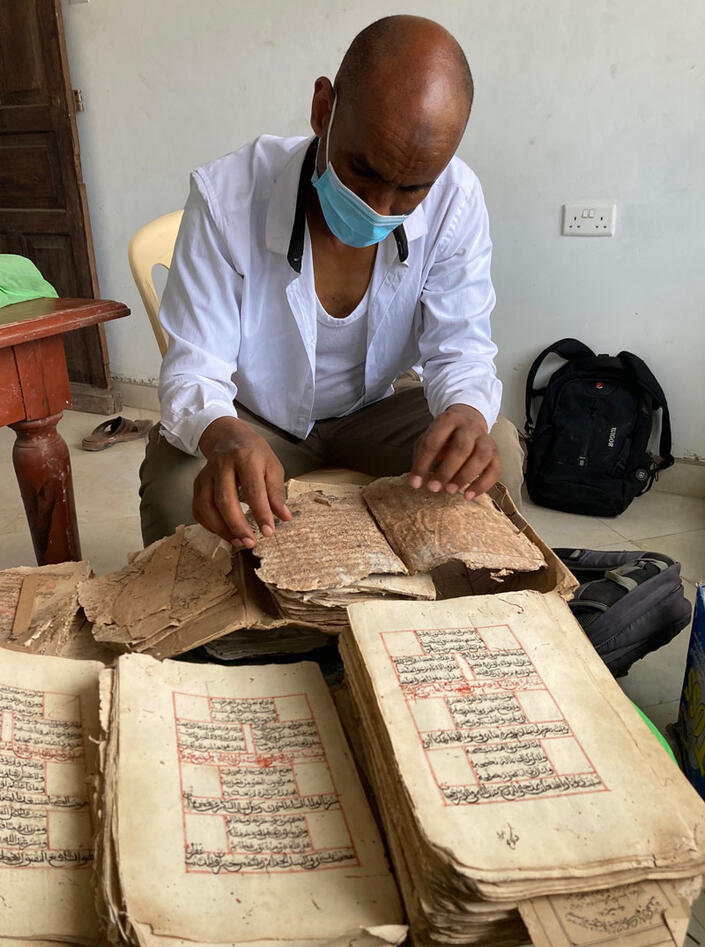 Man looking at an old islamic manuscript