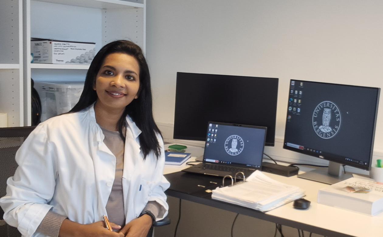 Young woman sitting at computer smiling at camera