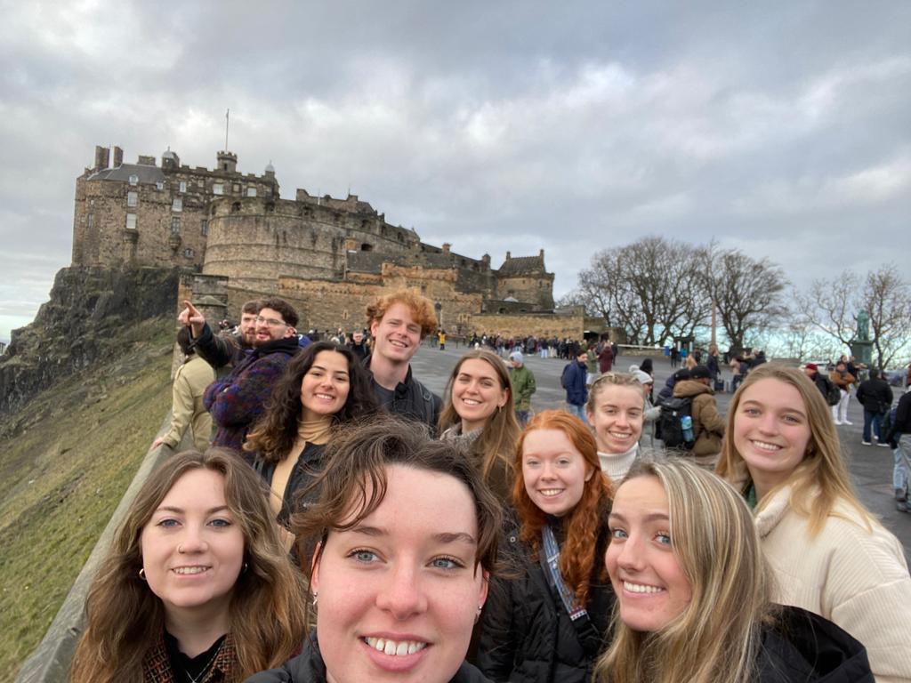 Studentar med slott i bakgrunn.