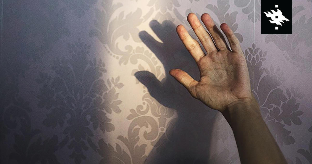 A hand in front of a wallpaper background