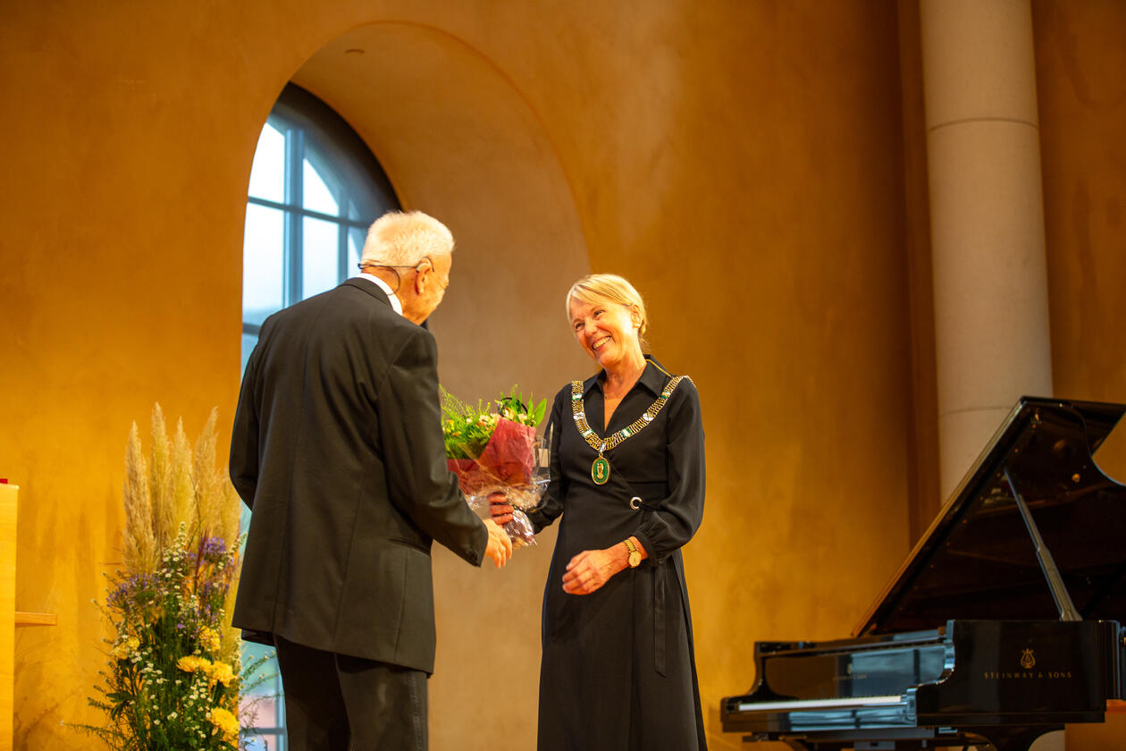 Rektor Margareth Hagen overrekker blomster til Jan Mangerud