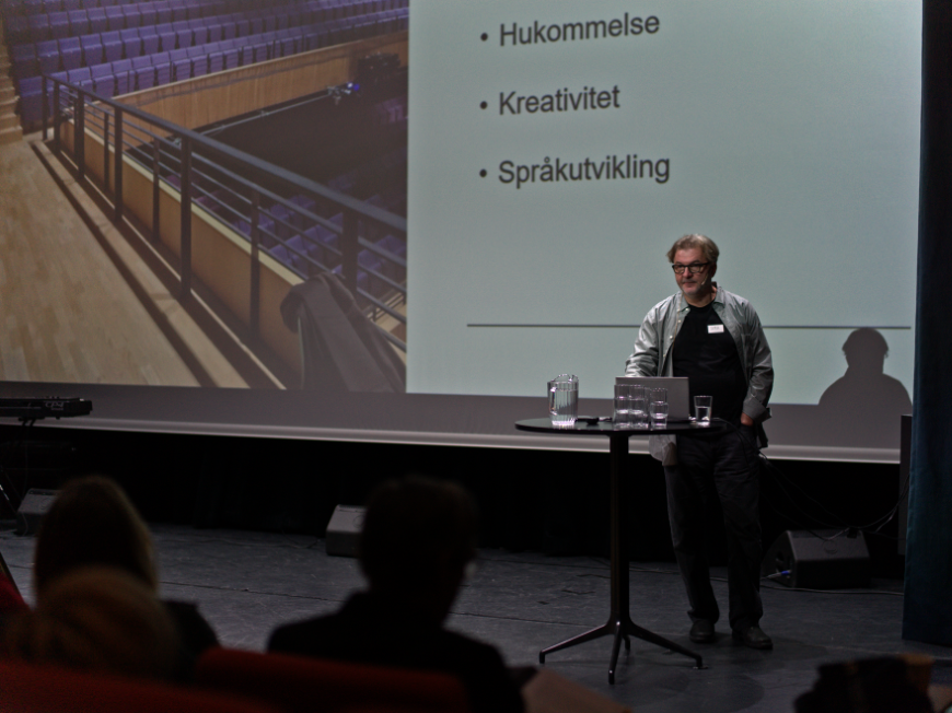 Semir Mujkic står på scenen og holder et foredrag