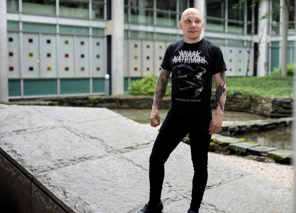 A portrait of a male student standing outside a building