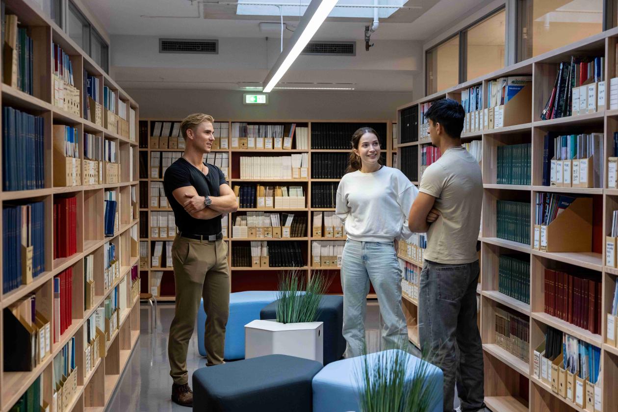 bilde av tre studenter som står i det medisinske biblioteket i Bygg for biologiske basalfag