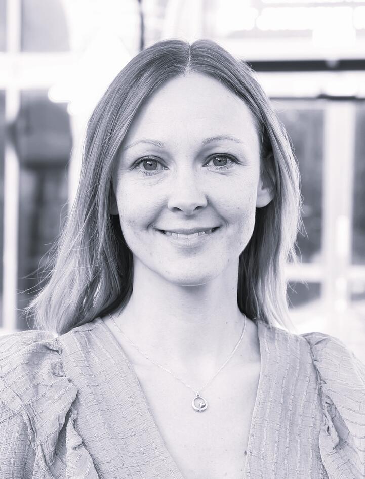 Black and white photo of a smiling young woman with long hair.