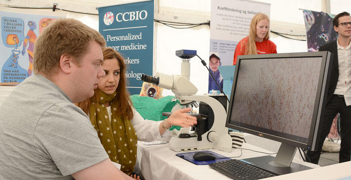 Pathologist explaining audience about cancer cells seen in microscope