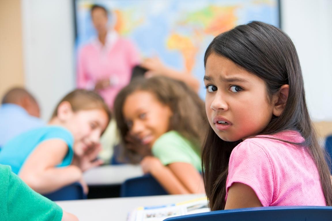 Barn i klasserom som blir baksnakket av  medelever