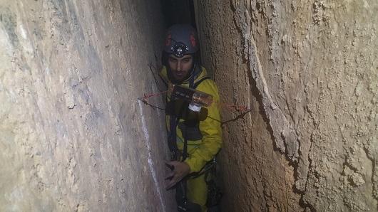 Bilde av Christos Pennos i en grotte under feltarbeid i Hellas
