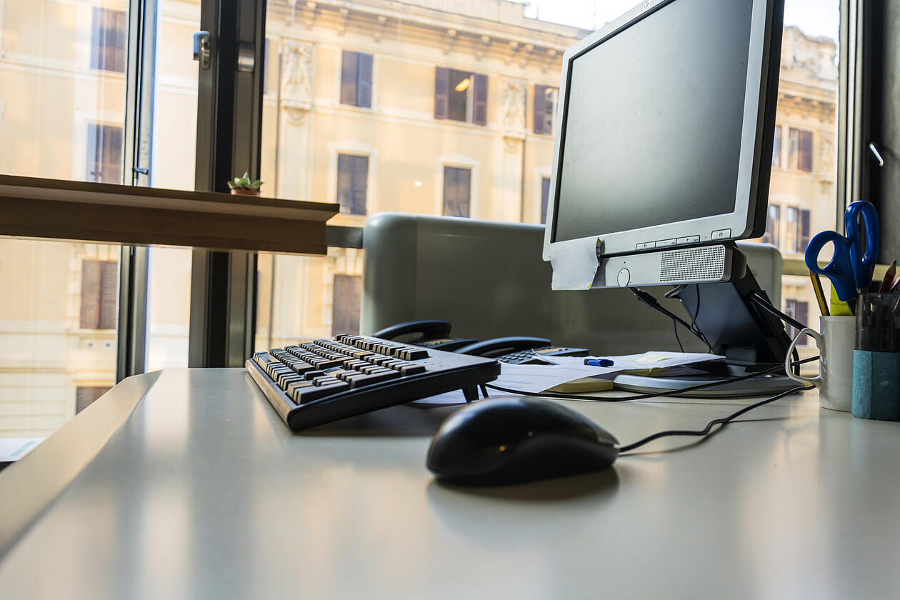 Bilde av kontorarbeidsplass med tastatur, mus og skjerm.