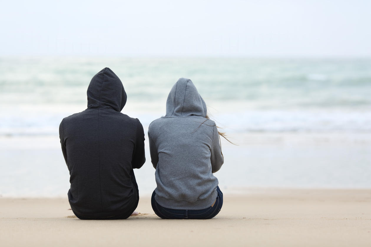 Two youths sitting on a beach