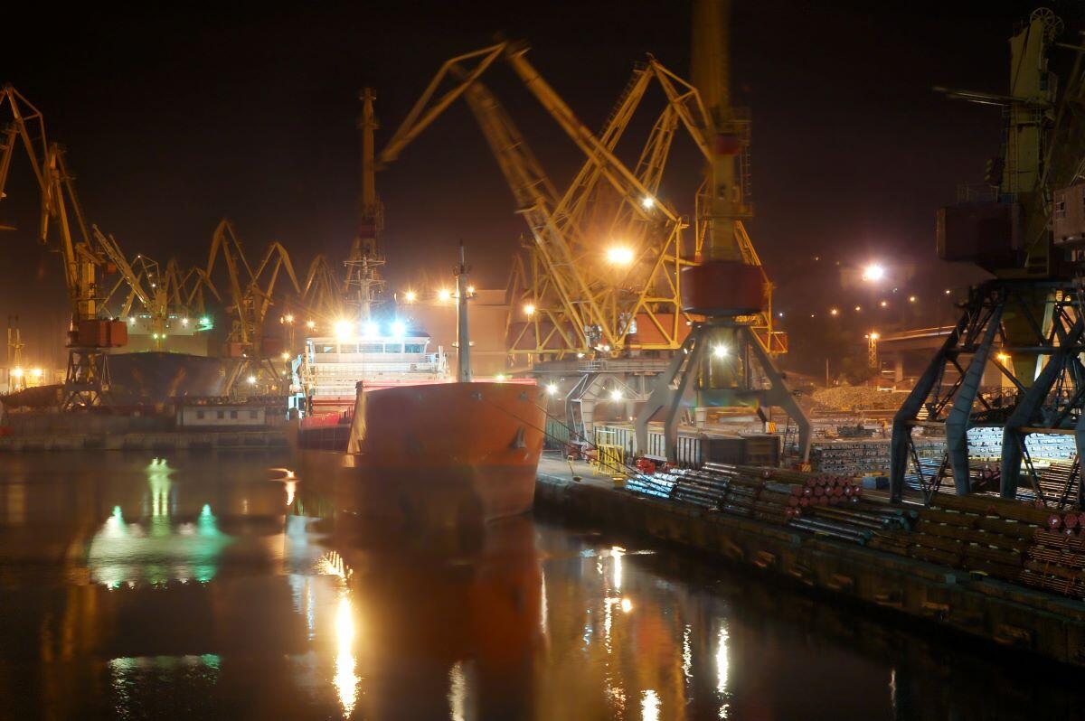 Container ship in a sea industrial freight port at night