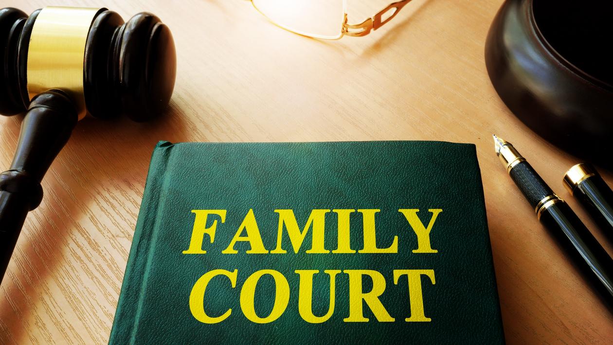 Bildet viser en dommerklubbe og en lovsamling med tittelen "Family court".