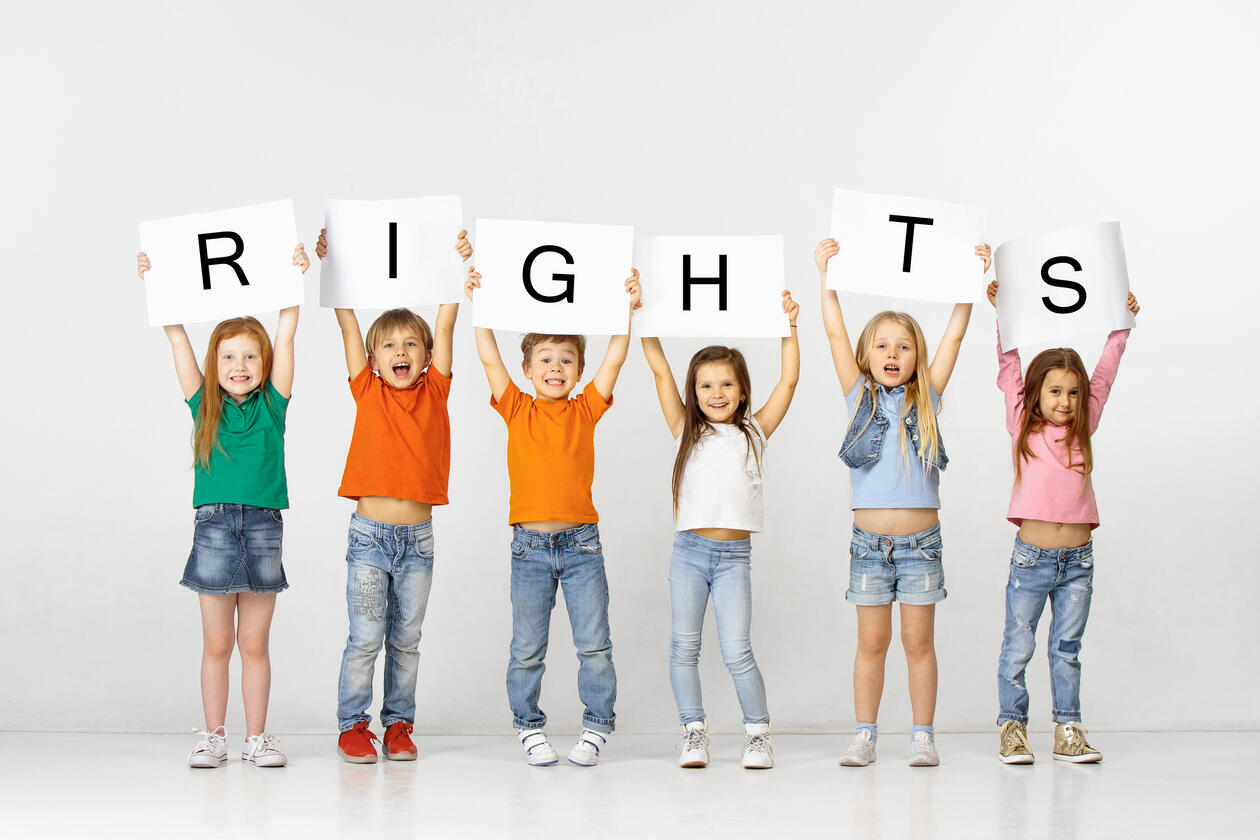 Glade barn som holder et skilt med teksten «rettigheter»