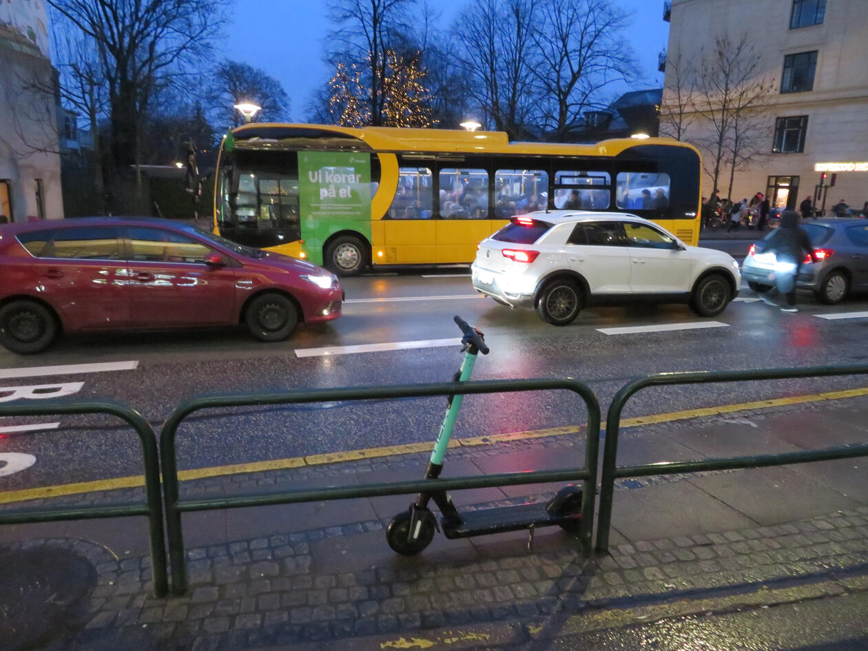 Street view with bus, cars and el-scooter