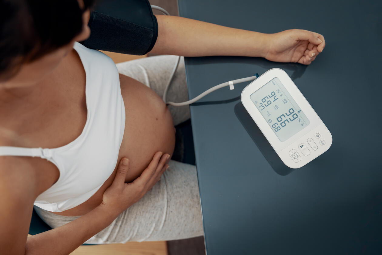 lady with baby bumb seen from above measuring blood pressure 