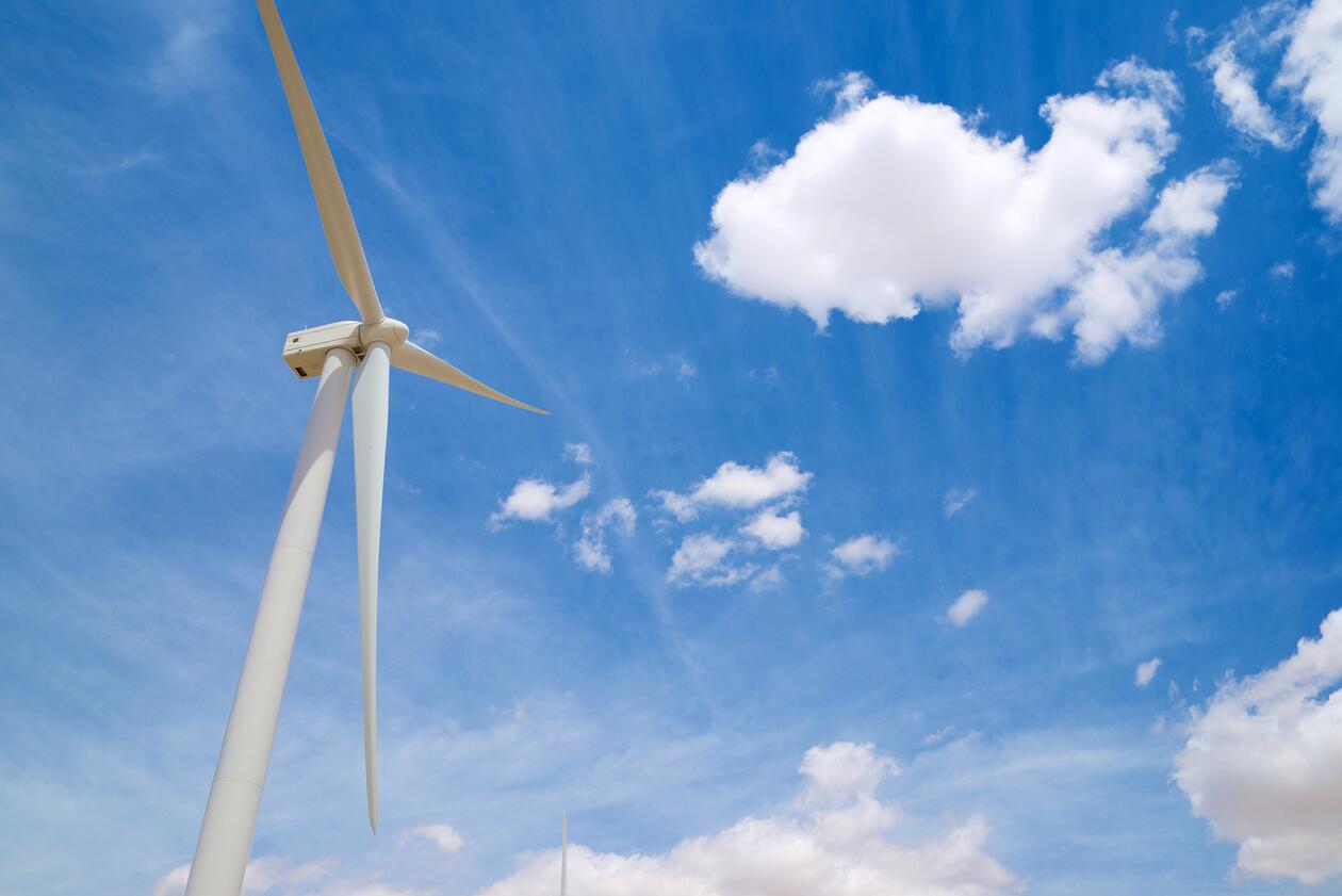 Image of a single windmill against a lightly clouded blue sky