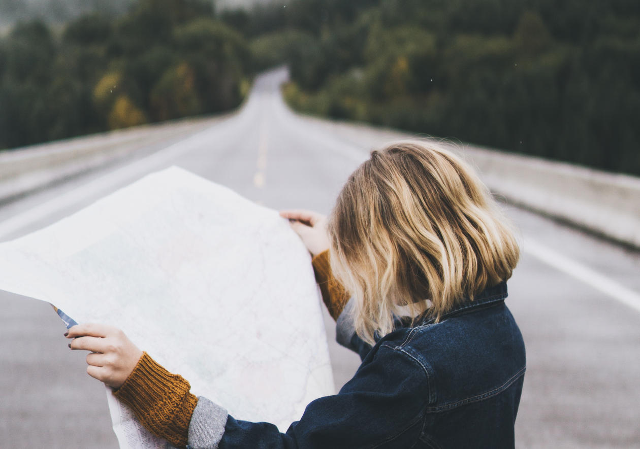 Kvinne står på veien og studerer et kart