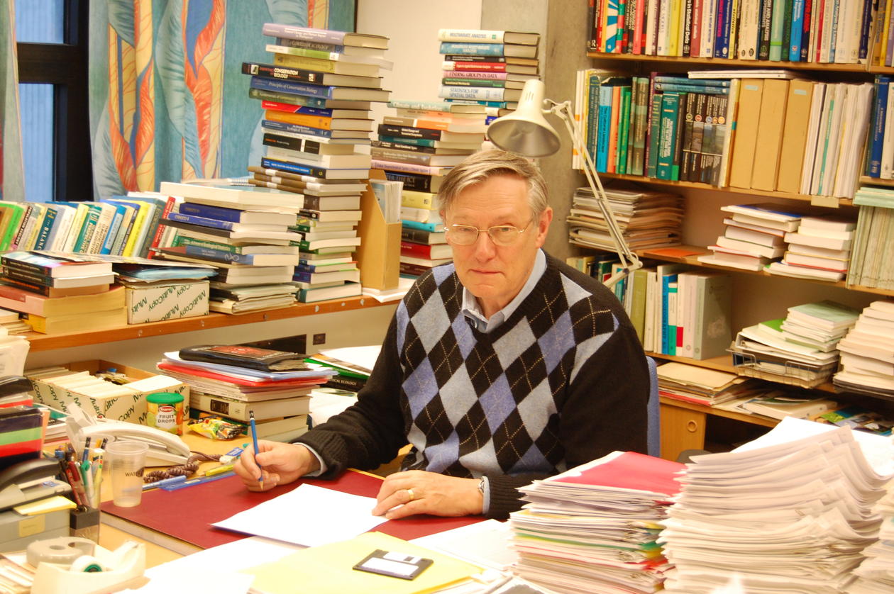 John in his office surrounded by books and papers of work in progress