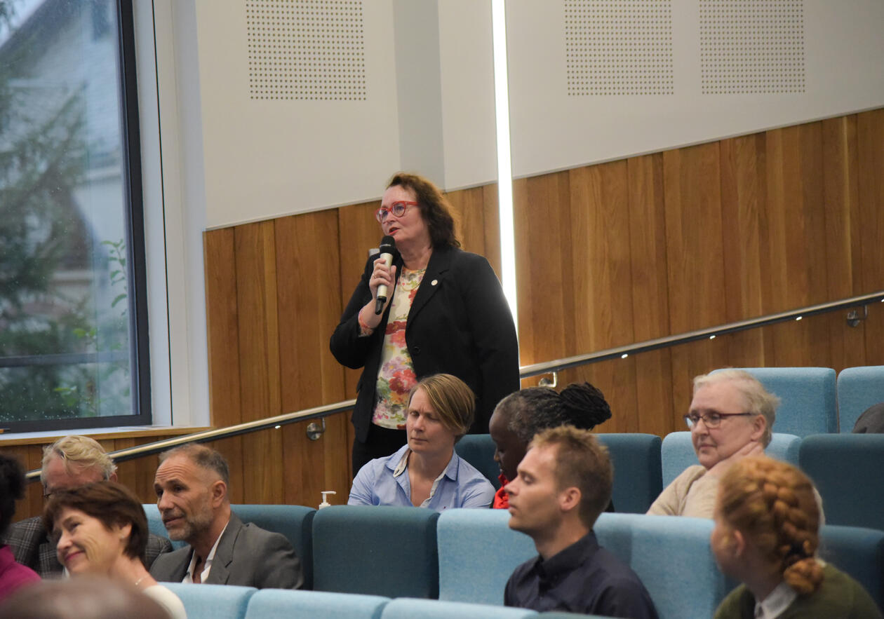 Eva Gerdts holder mikrofonen for å stille rektor et spørsmål