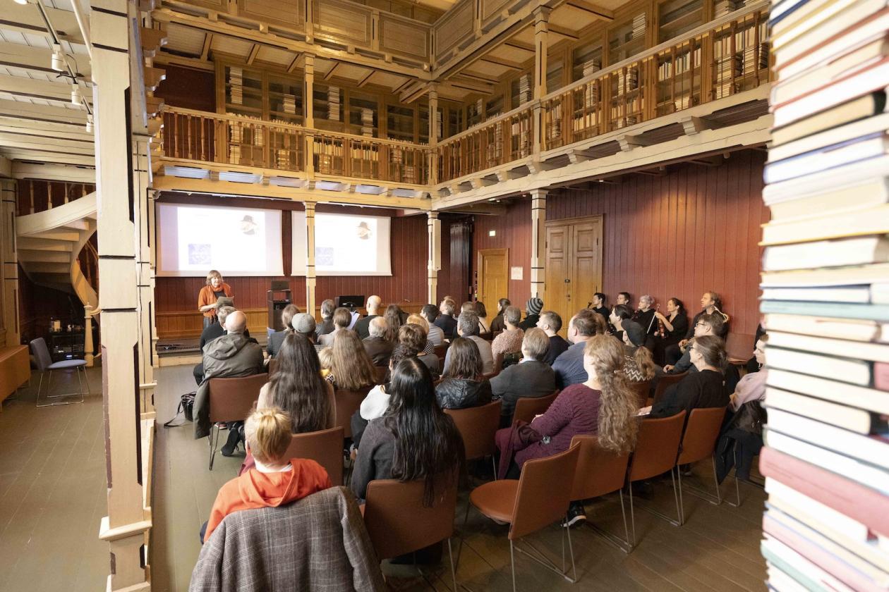 Mennsker sitter og følger med på forelesning i Tårnsalen på Universitetsmuseet
