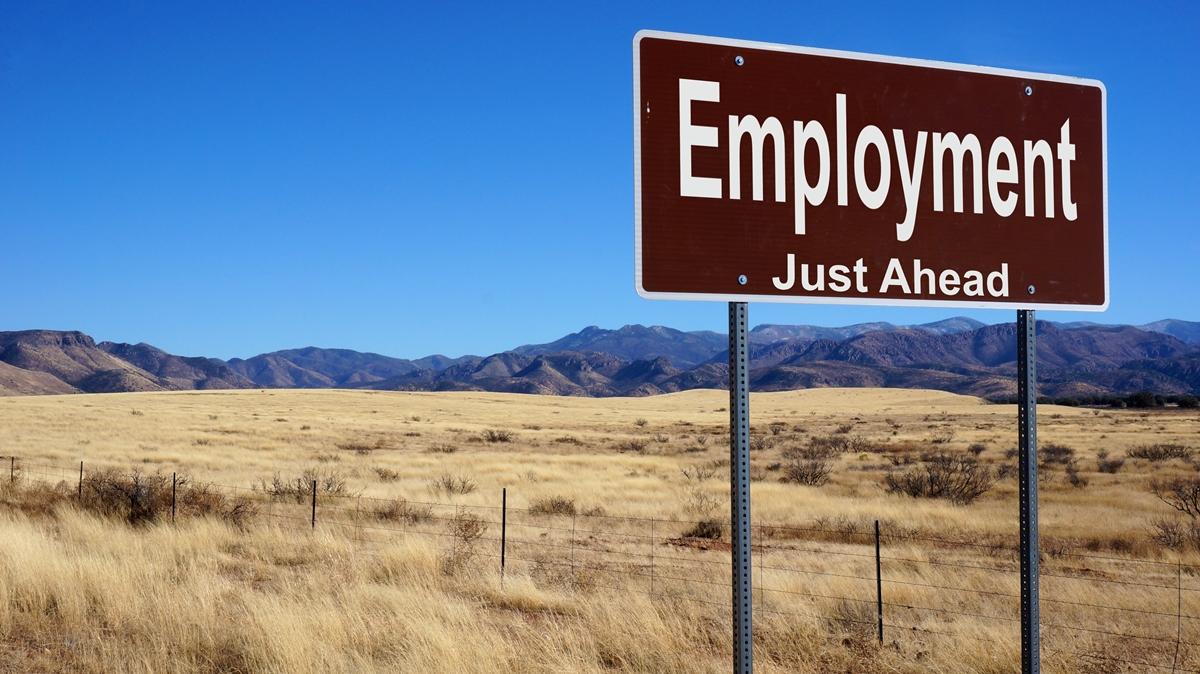 A sing with the text: "Employment Just Ahead" Placed in a barren landscape