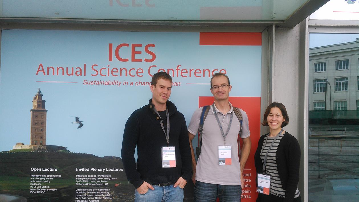 Fabian, Mikko and Bea posing in front of the conference poster