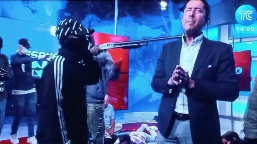 Masked gang members threatening TV presenter with weapon