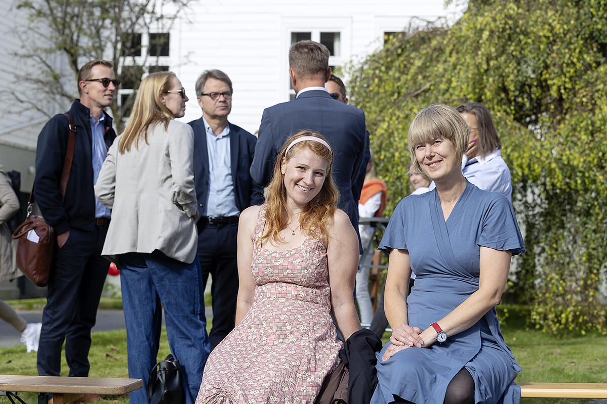 To damer sitter sammen på en benk