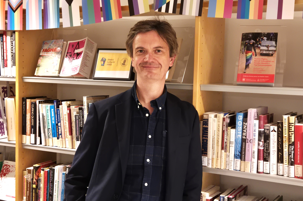 Prisvinner Frode Helmich Pedersen foran bokhylle.