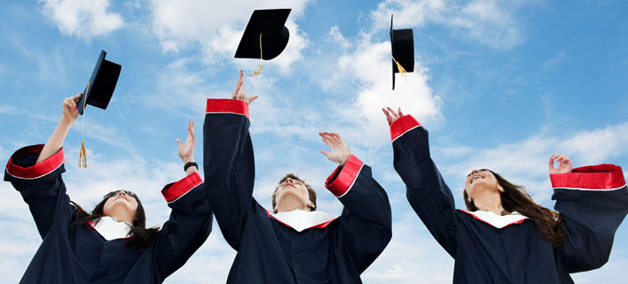 happy students graduating, thwoing their caps in the air.