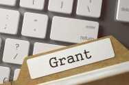 Illustration picture. Close-up of a file folder marked with “grant” lying on the enter key of a keyboard.