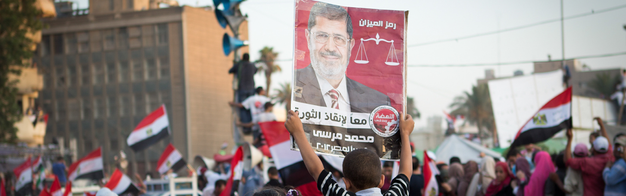 Ein gut held opp ein plakat av Muhammad Morsi, Egypts tidlegare president.
