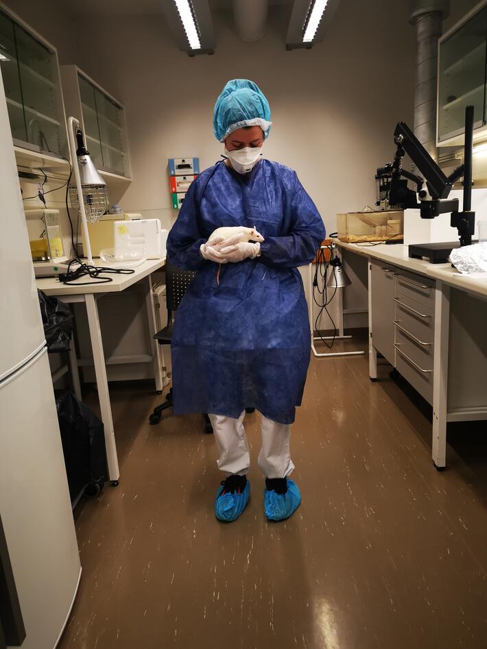 En av forskerne i studien holder en rotte i hendene sine på labben
