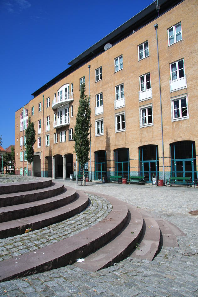 Fakultetsbygget og plassen foran i solskinn