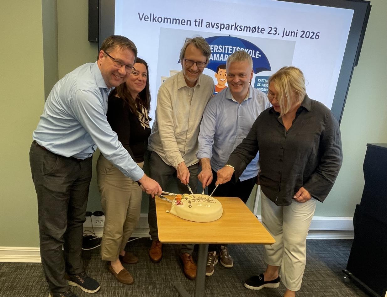 Rektorene ved universitetsskolene skjærer opp kake 