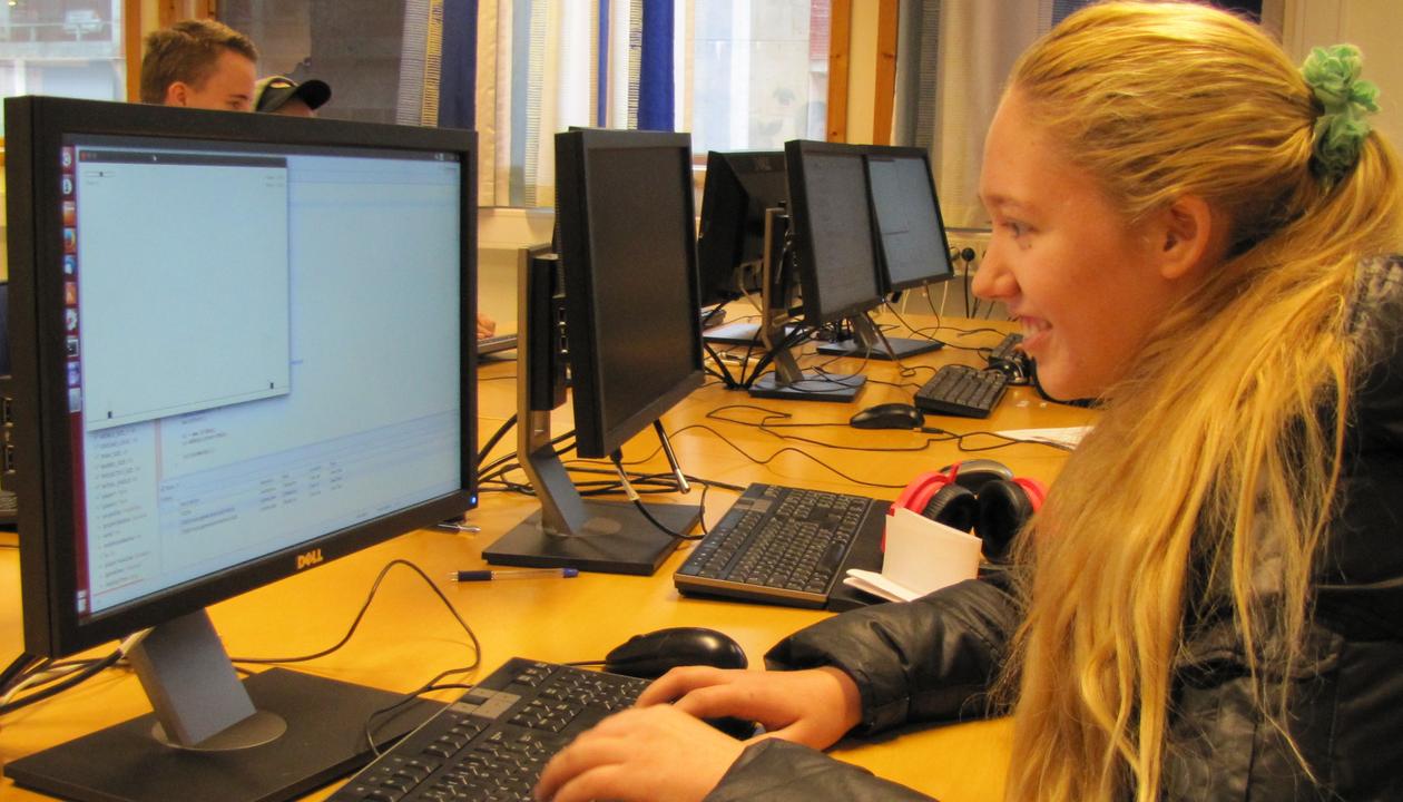 En jente spiller engasjert foran datamaskinen