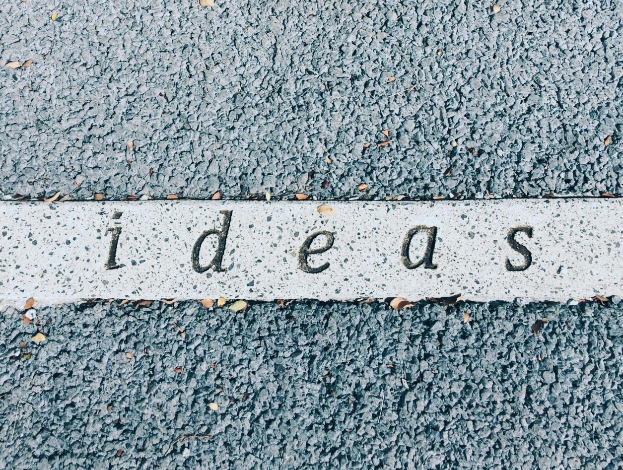 Ordet "ideas" skrevet på asfalt