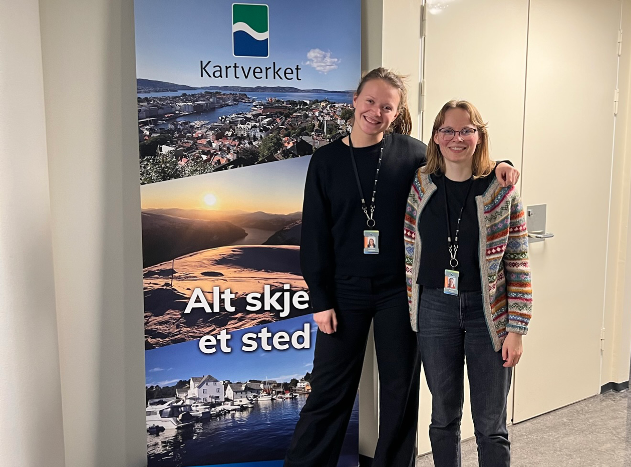 Julie og Emma ved banner for Kartverket