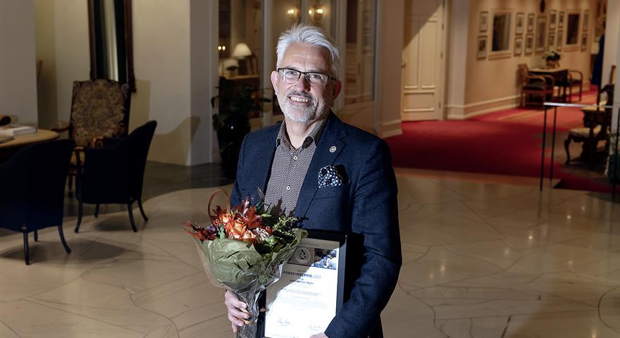 Kjell-Morten posing with the diploma and flowers.