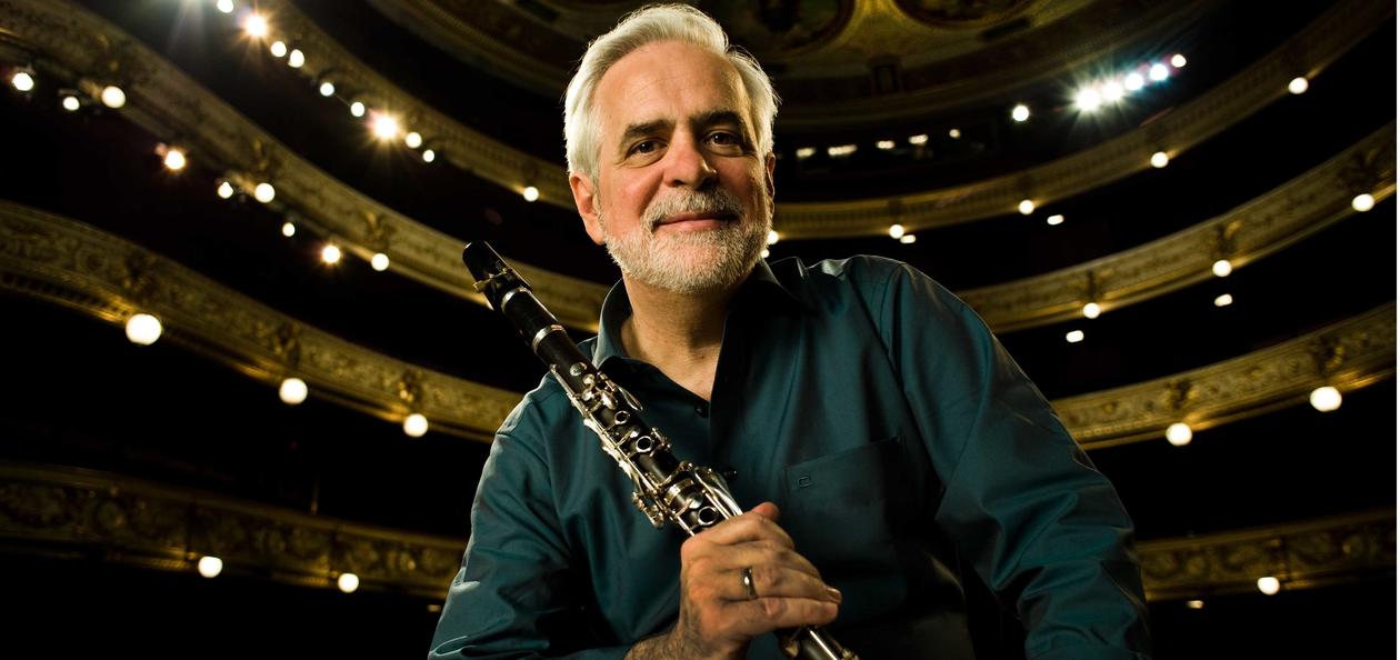 portrett av lee morgan, smilende, med ryggen mot en konsertsal. i sin høyre hånd holder han en klarinett