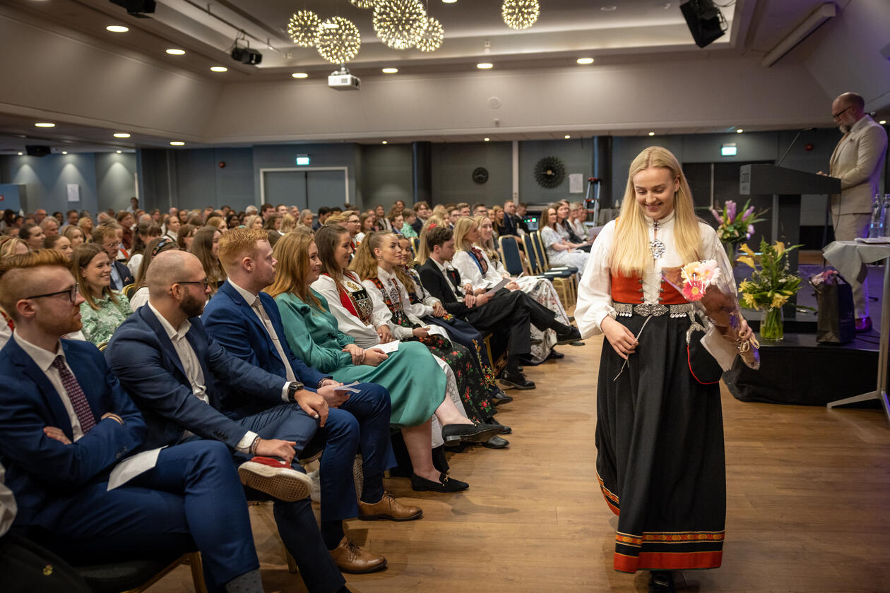 Jente i bunad med blomar i hendene