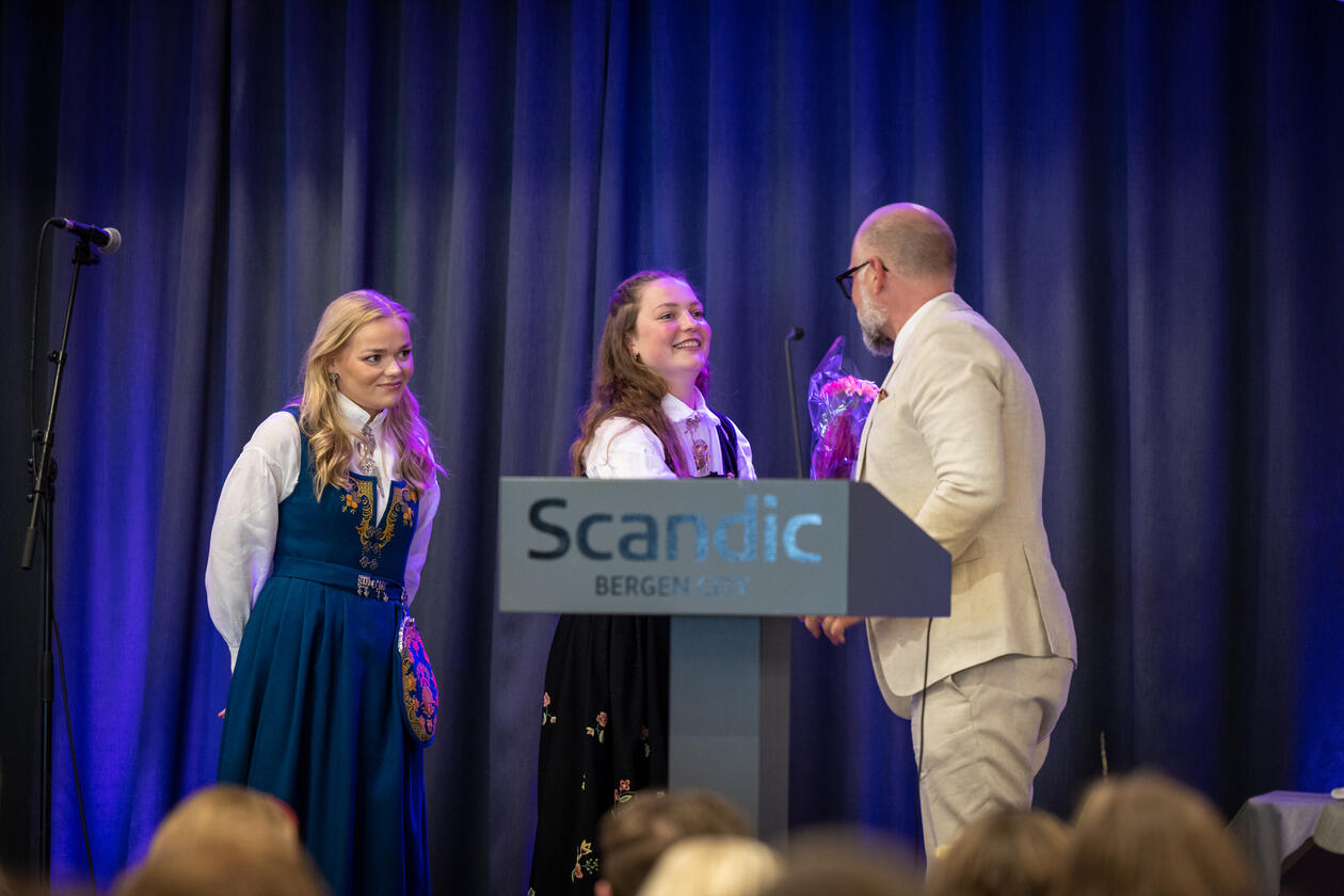 to  jenter som får blomar av konferansier 