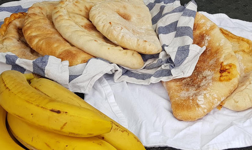 Gruppa nærar seg med pizza, banan, og sjokolade (allereie oppeten). Lunsj