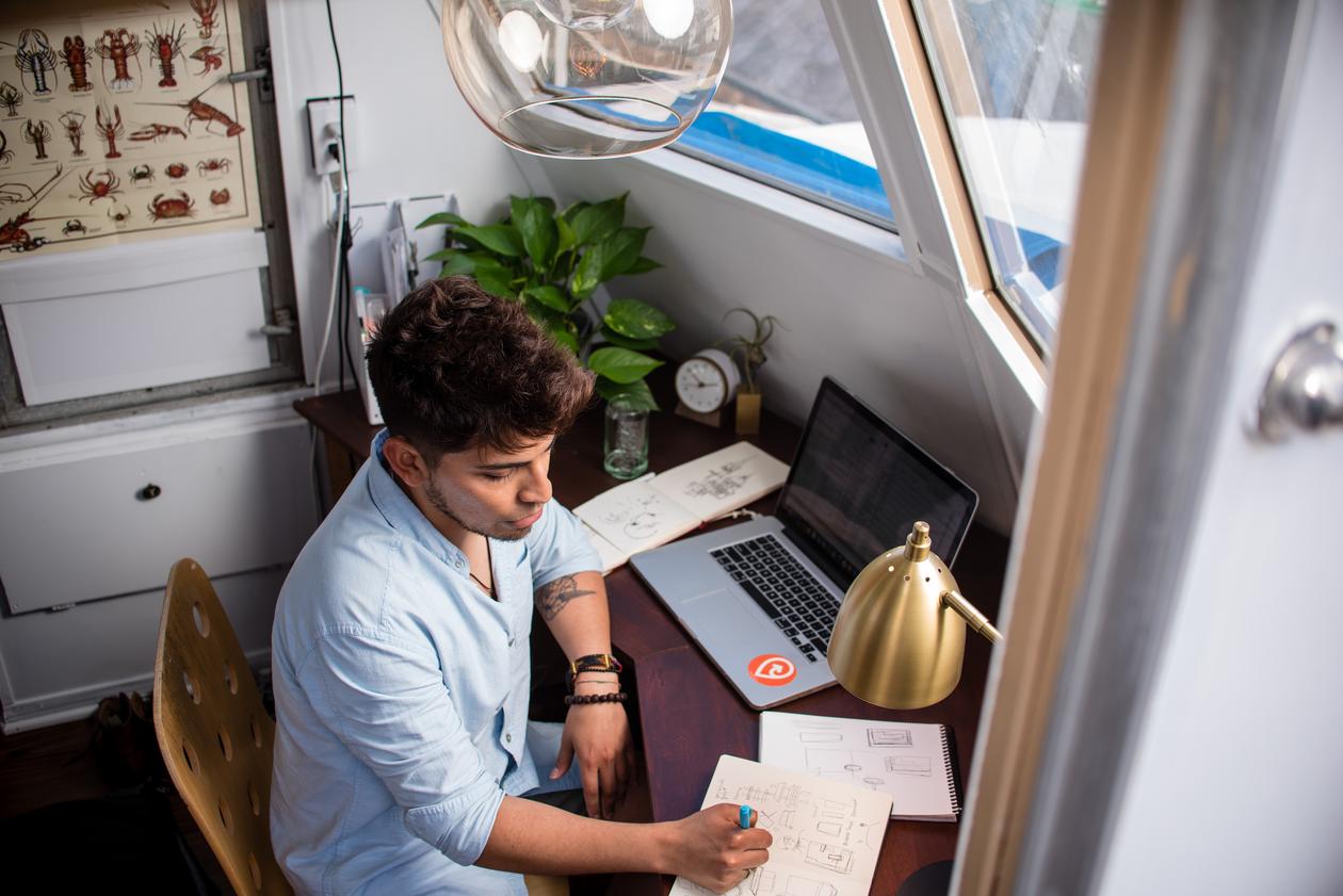 Student som sitter foran en laptop og jobber med skoleeksamen - hjemme 